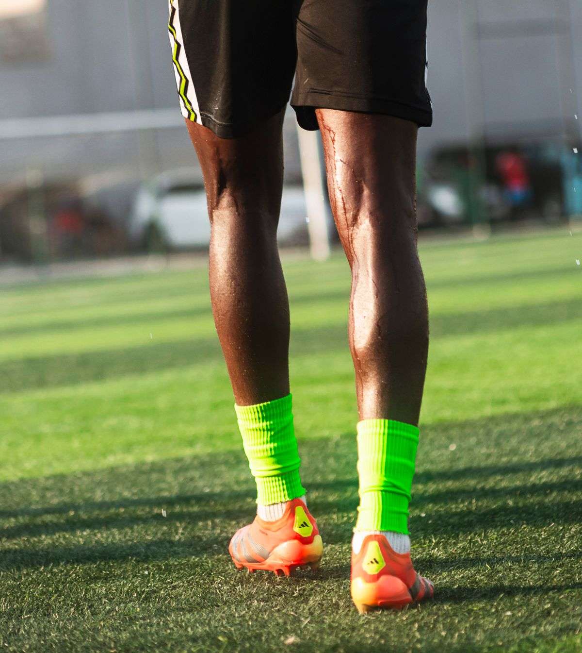 Close-up of a footballer's legs on a grass field, representing athlete body-part insurance policies