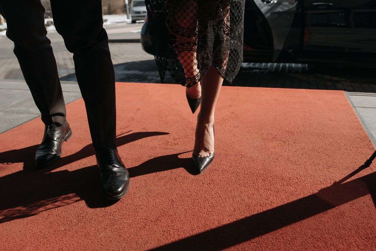 Couple walking a red carpet at a glamorous event, representing Hollywood celebrity body value calculator
