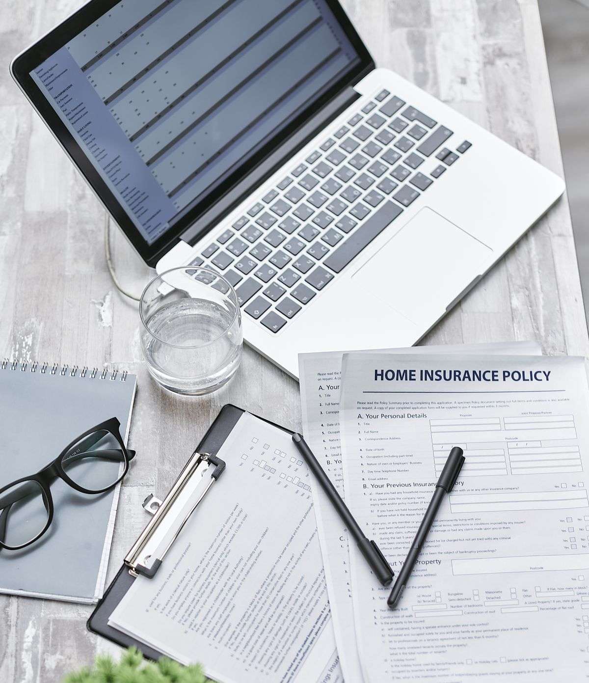 Insurance policy document and laptop representing celebrity body-part insurance policies